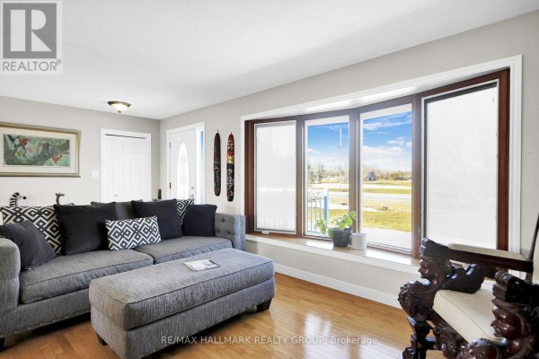 Gray sectional sofa and bay window with hardwood floors - 6151 Malakoff Road Ottawa