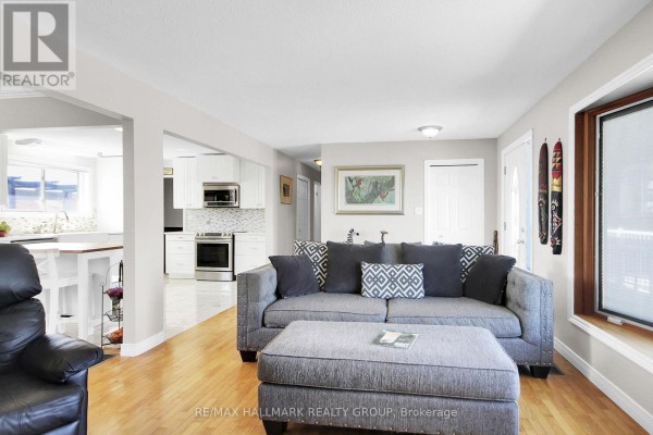 Gray sectional sofa and ottoman in living room with open view to kitchen - 6151 Malakoff Road Ottawa