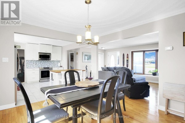 Dining room and kitchen with modern chandelier and updated appliances - 6151 Malakoff Road Ottawa