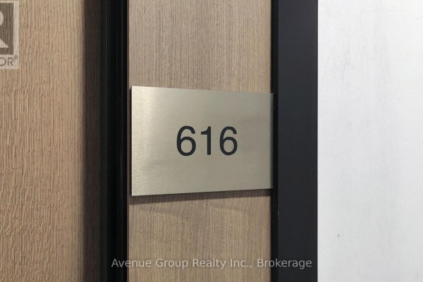Apartment hallway with wood doors, mirrored closet, and white walls. - 616 - 8 Tippett Road, Toronto