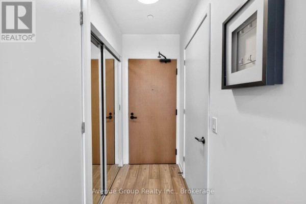 Open concept living space with white island, stainless steel appliances, and balcony doors. - 616 - 8 Tippett Road, Toronto
