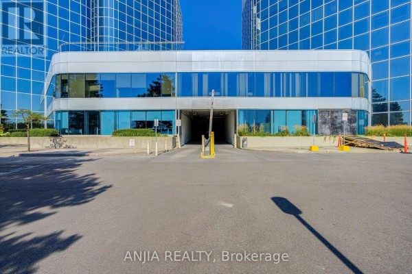 Entrance to an underground parking garage with a yellow barrier gate. - 617 - 105 Gordon Baker Road, Toronto