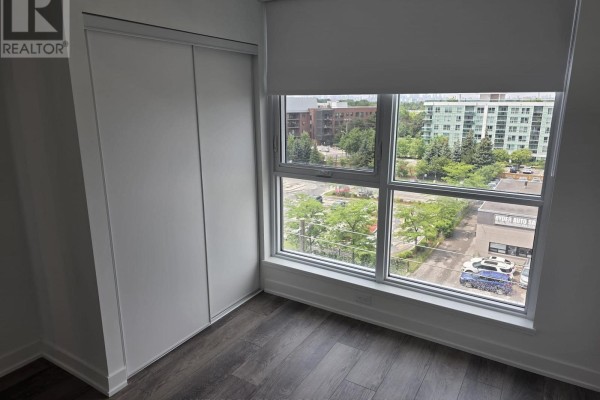 Bedroom with a large window and view of city street. - 617 - 20 Deans Drive, Toronto