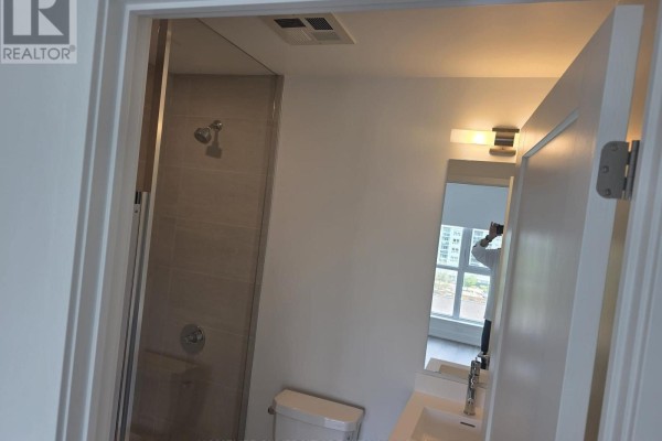 Small bathroom with a tiled shower stall and toilet. - 617 - 20 Deans Drive, Toronto