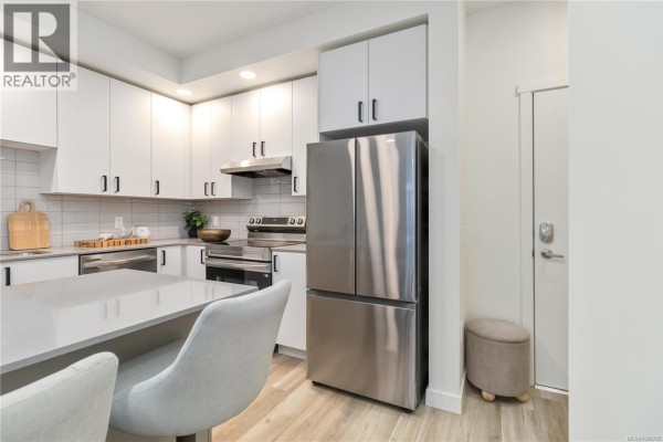 Close-up of a double sink, faucet, and grey subway tile backsplash in a kitchen. - 617 2390 City Gate Blvd, Langford