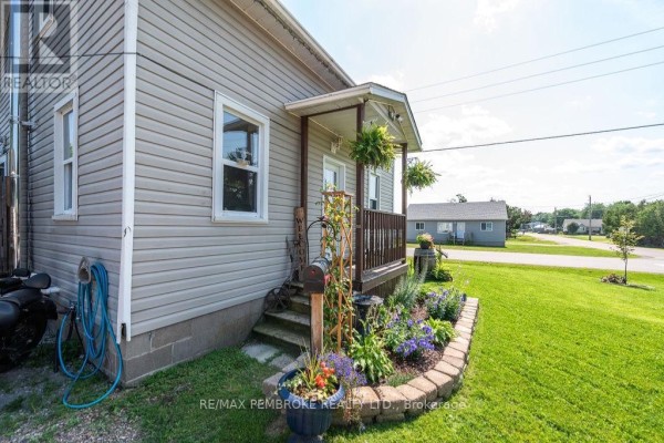 Close-up of the front porch stairs and flower bed, showing a mailbox and decorative plants. - 617 Third Avenue S, Laurentian Valley
