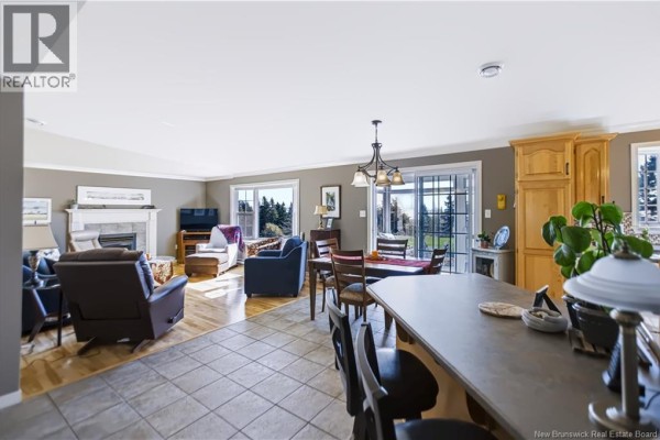 Open concept living and dining area with a fireplace, island, and sliding doors to the outside. - 618 Route 935, Wood Point