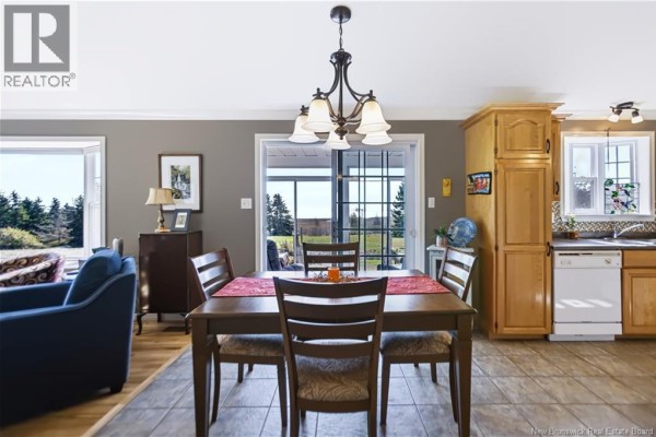 Dining area with a wooden table and chairs, overlooking the backyard through sliding doors. - 618 Route 935, Wood Point