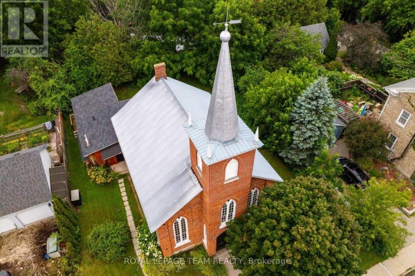Close-up aerial view of the church steeple, showing brickwork, windows, and a weather vane. - 618 St. Lawrence Street, Merrickville Wolford