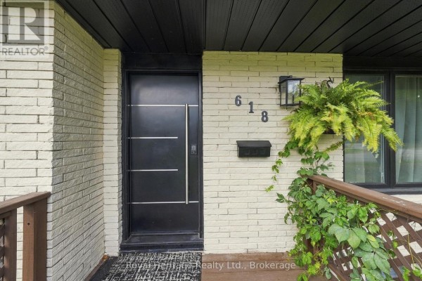 Close-up of a modern black front door with horizontal lines, house number 618, and a mailbox. - 618 Sunset Boulevard, Clarington