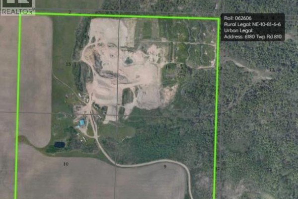 Aerial view of a large gravel pit with piles of material, heavy equipment, silos, and surrounding trees. - 6180 Township Road 810, Rural Saddle Hills County