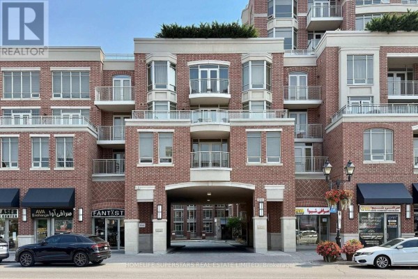 Facade of the brick apartment building with arched entryway and balconies. - 619 - 10101 Yonge Street, Richmond Hill