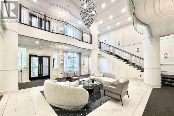 Two-story lobby with seating area, staircase, and modern chandelier. - 619 - 10101 Yonge Street, Richmond Hill