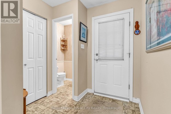 Interior hallway with a closet, a half bathroom, and a back door. - 62 - 201 Silvercreek Parkway N, Guelph