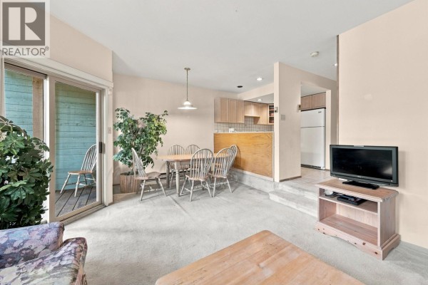 Dining area adjacent to the living room, with a table and chairs and view of the kitchen. - 62 6127 Eagleridge Crescent, Whistler