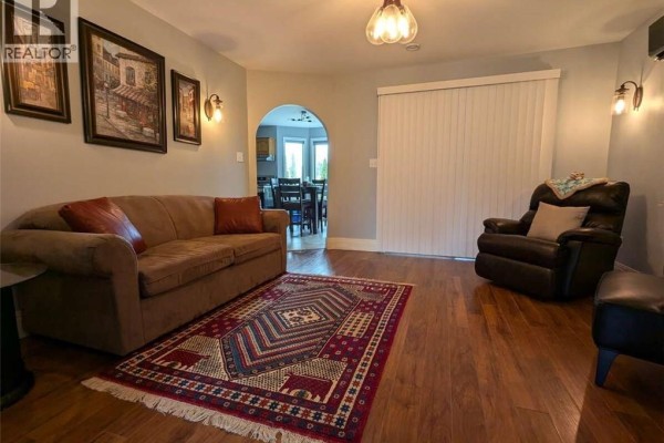 Sunroom with a desk, chair, and floor-to-ceiling windows covered in hanging plants. - 62 Bateman Promenade, Shediac