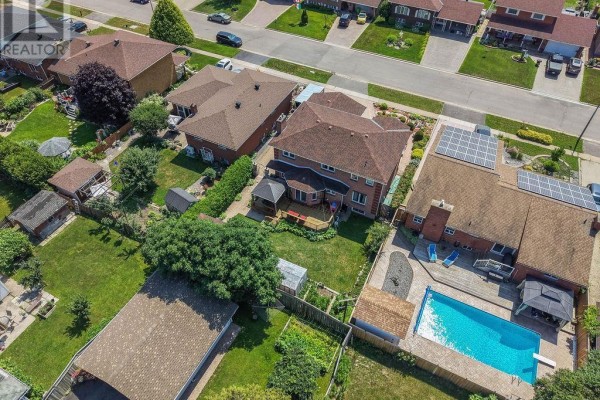 Aerial view of the backyard featuring a swimming pool, deck, grassy lawn, and surrounding fences. - 62 Bitonti Cres, Sault Ste  Marie