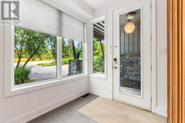 Bright entryway with large windows overlooking the exterior, featuring a glass door. - 62 Carrick Trail, Gravenhurst)