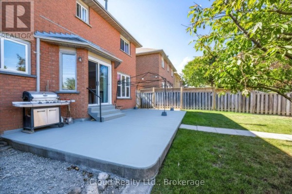 Backyard patio with a gas grill, green grass, and wooden fence. - 62 Castlehill Crescent, Brampton