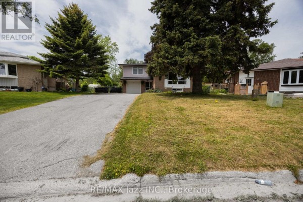 Driveway curves towards the front entrance of a two-story house with brick and siding exterior. - 62 Crossley Drive, Port Hope