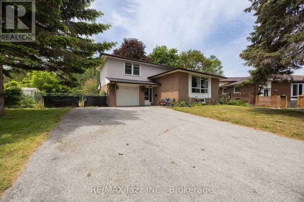 Paved driveway extends from the street to the attached garage of a suburban residence with brick facade. - 62 Crossley Drive, Port Hope