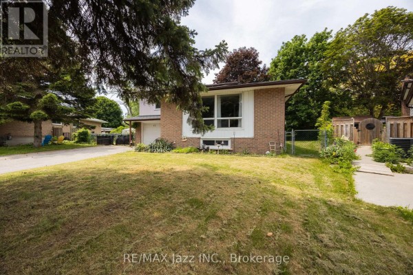 Side view of a brick suburban house showing its lawn, partial fence, and adjacent properties. - 62 Crossley Drive, Port Hope