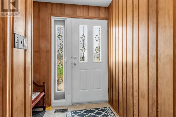 Spacious living room and dining area with hardwood floors, a stone fireplace, and a view of the street through the window. - 62 Dukinfield Crescent, Toronto