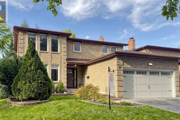 Front view of a two-story brick house with manicured bushes and a double garage. - 62 Emeline Crescent, Markham