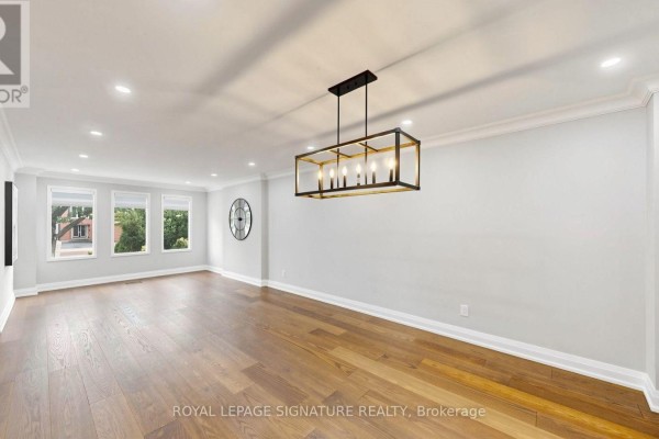 Wide shot of a bright dining room with hardwood floors, large windows, and a modern chandelier. - 62 Emeline Crescent, Markham