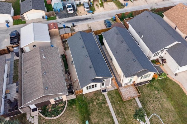 Aerial view showing the rear of several Winnipeg homes with attached garages and backyard decks. - 62 La Porte Drive, Winnipeg