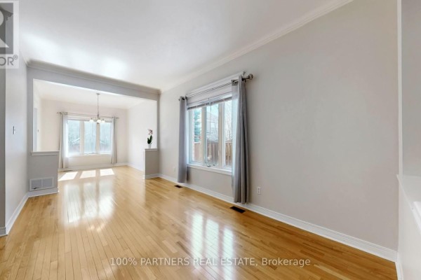 Kitchen with wooden cabinets, stainless steel appliances, and tile flooring, leading to dining area. - 62 Macedonia Court, Newmarket