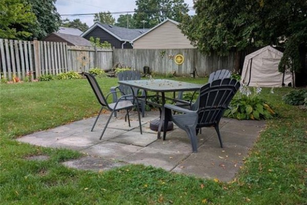 Backyard with patio, dining set, shed, and fence - 62 Ninth Avenue Brantford