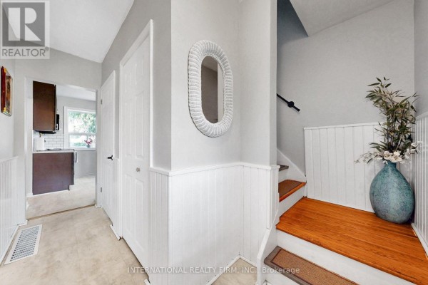 Interior hallway with doors, staircase, and a view into the kitchen. - 62 Porchester Drive, Toronto