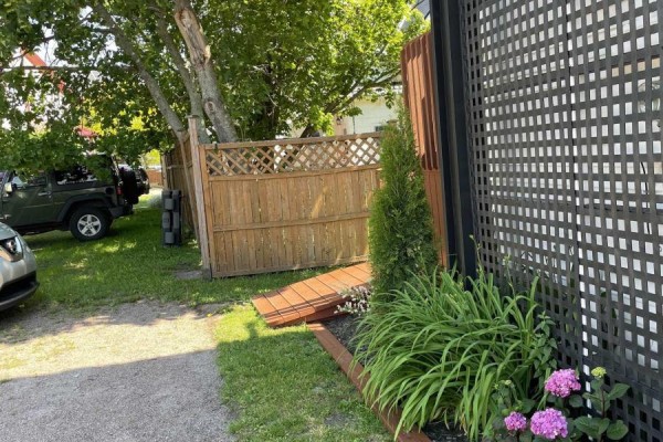 Side view of a two-story building with white siding, multiple entrances, exterior staircases, and balconies. - 62 School Street, Parrsboro