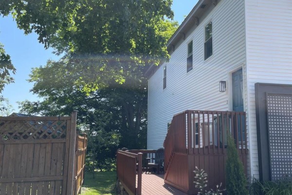 Kitchen area with white refrigerator, washing machine, dryer, sink, and wooden cabinets. - 62 School Street, Parrsboro