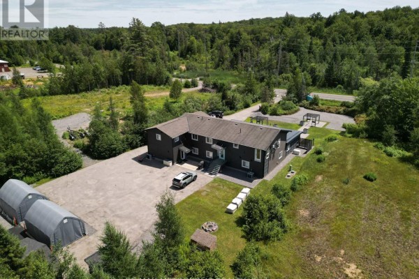 Aerial perspective of a commercial property with hoop buildings and expansive green landscape. - 62 South Mary Lake Road S, Huntsville