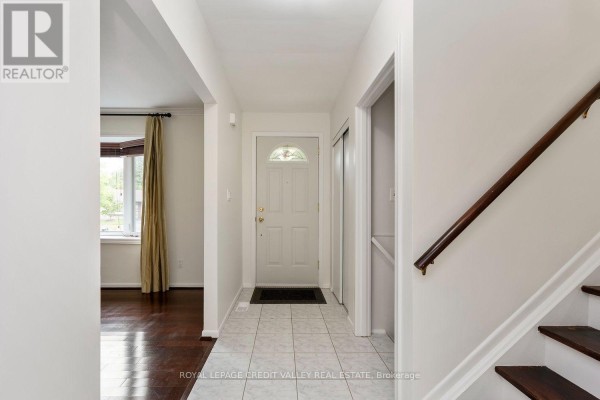 Interior entryway with a tiled floor, white walls, and a view of a living room. - 62 Summerside Crescent, Toronto