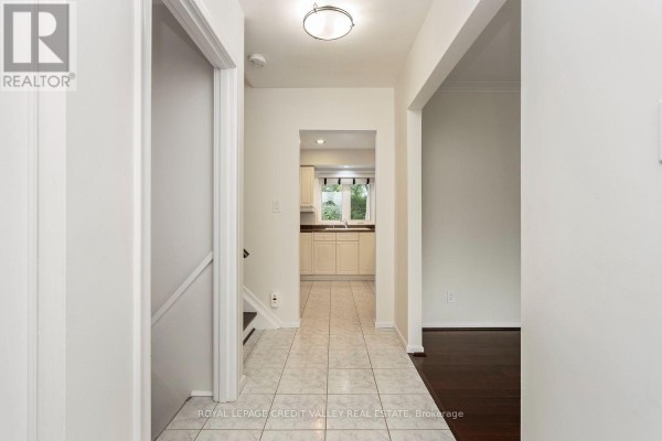 View down a hallway towards a kitchen and stairs to the basement. - 62 Summerside Crescent, Toronto