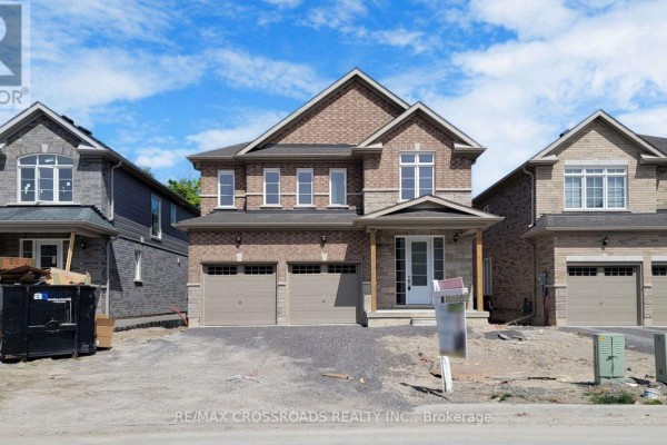 Front exterior of a brick house with a covered porch and two garage doors. - 620 Lemay Grove, Peterborough