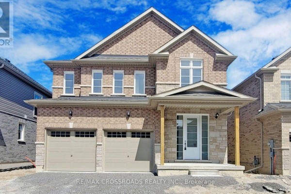 A newly constructed house with beige brick exterior, double garage, and stone accents. - 620 Lemay Grove, Peterborough