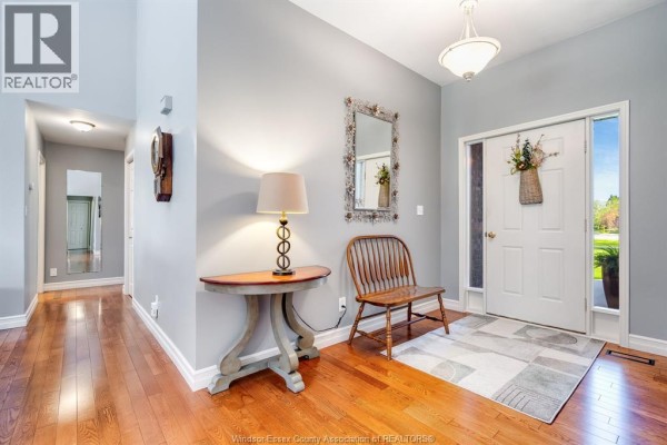 Spacious living room with vaulted ceiling, fireplace, large windows, and hardwood floors. - 621 County Rd 20, Kingsville