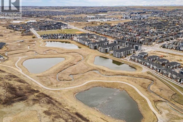Aerial view of apartment buildings adjacent to wetlands and walking paths. - 6215, 15 Sage Meadows Landing Nw, Calgary