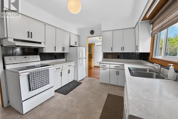Corner view of a white kitchen with white cabinets, stainless steel sink, and dishwasher. - 6219 Highway 542, Mindemoya, Manitoulin Island