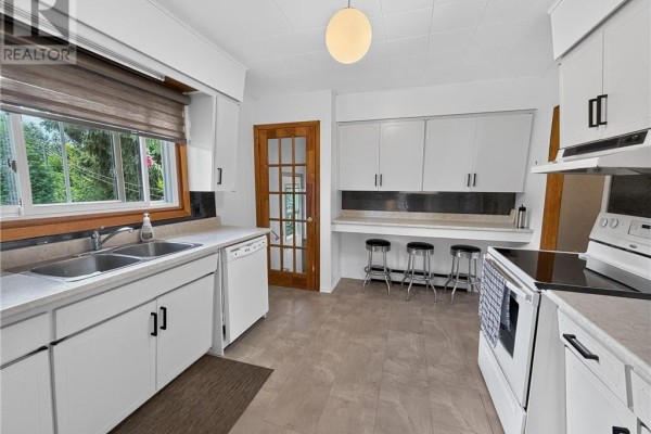 Kitchen with double sink, white cabinets, and stool seating - 6219 Highway 542 Mindemoya, Manitoulin Island