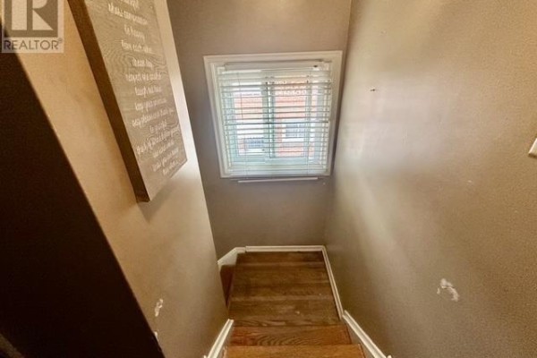 Wooden staircase and wall art in hallway - 622 Placid Ave Sault Ste Marie
