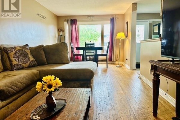 Living room with sectional sofa, dining table, and hardwood floors - 622 Placid Ave Sault Ste Marie