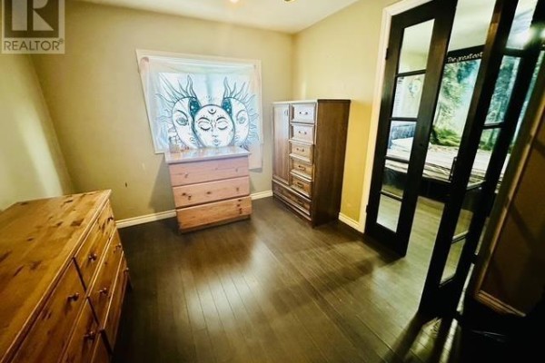 Bedroom with wooden dressers and sliding glass doors - 622 Placid Ave Sault Ste Marie