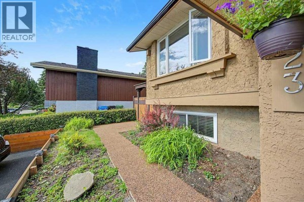 Aerial view of the residential property with a detached garage and green lawn. - 623 Cantrell Place Sw, Calgary