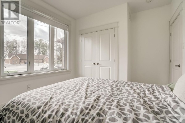Home office with a desk, computer setup, and large window for natural light. - 6237 Perth Street, Ottawa