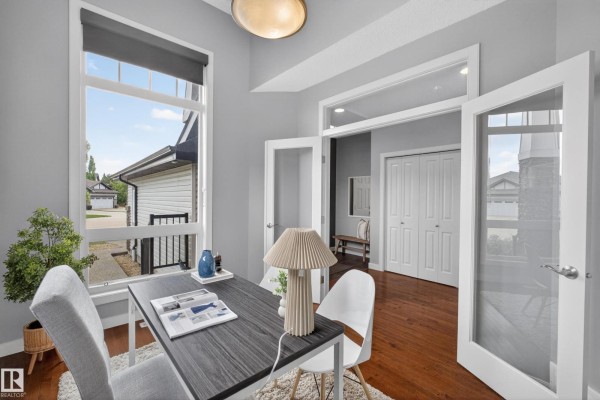 A home office with a desk, chairs, French doors, and a view of the exterior. - 624 Cantor Ld Sw, Edmonton